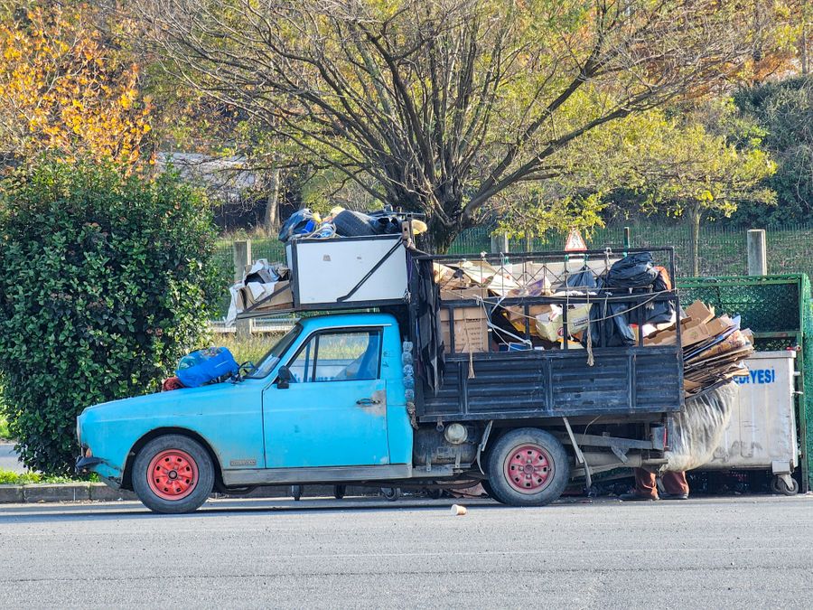 A pickup truck loaded with hauled-away material parked on a residential street