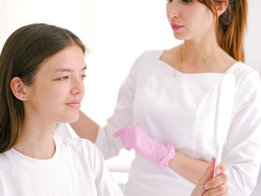 A dermatologist talking with a patient in a bright clinic room